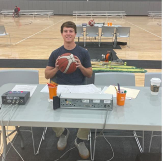 Student at a desk holding a basketball
