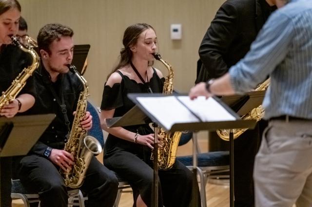 Music students playing with sheet music in the foreground